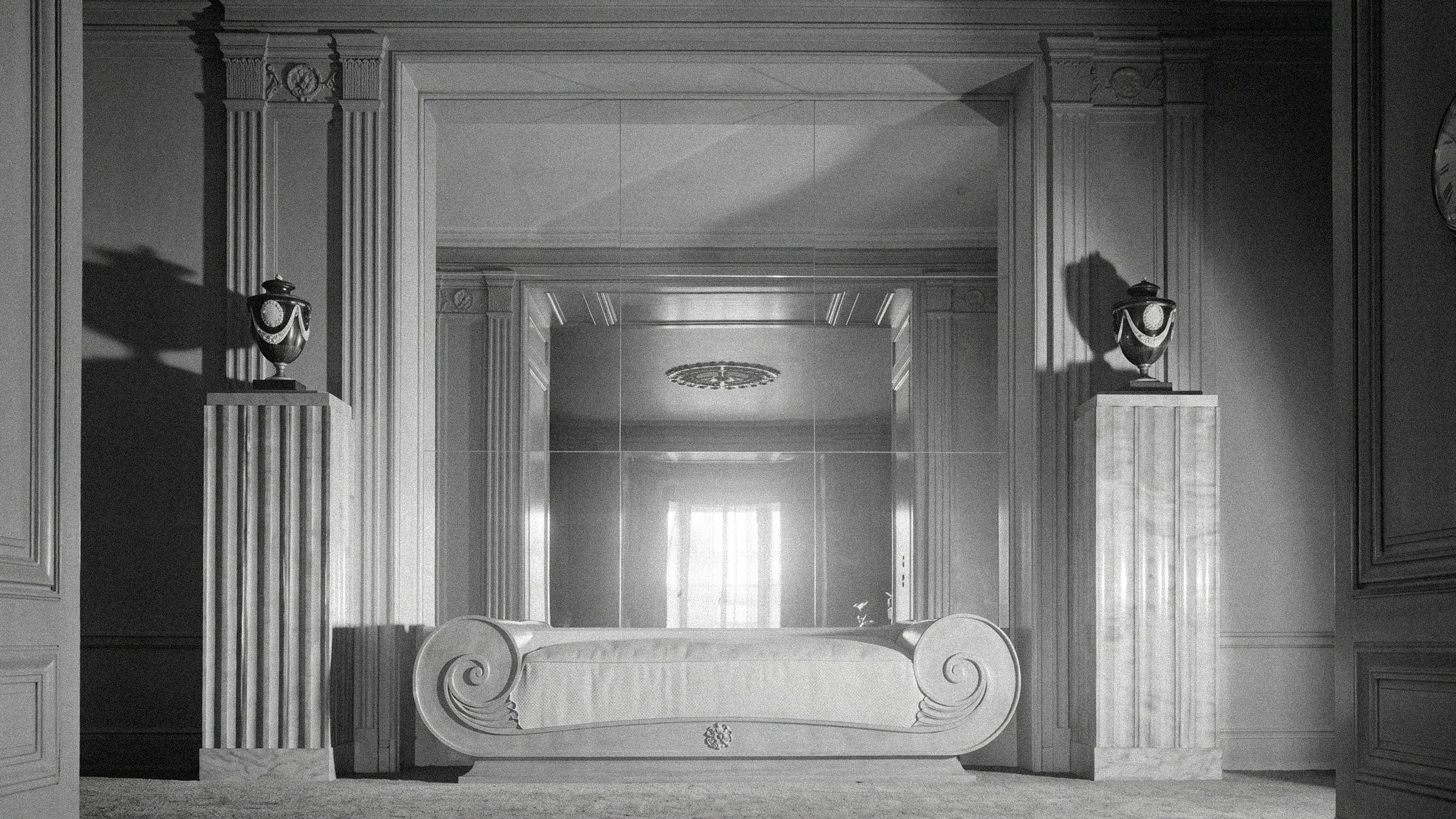 Neoclassical salon with a scrolled daybed between two fluted pilasters